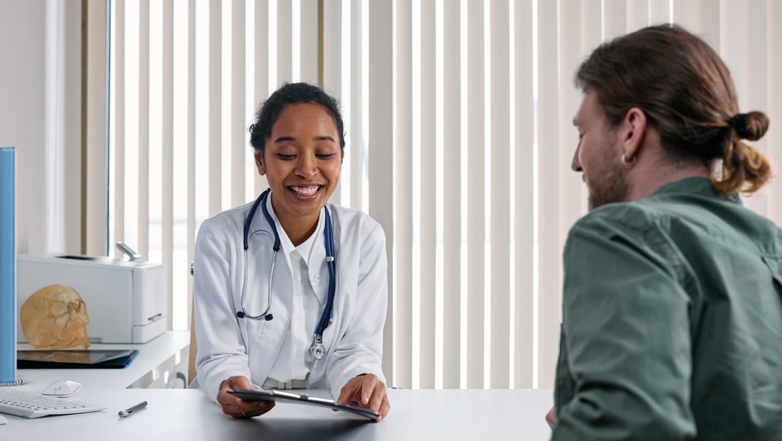 Médica conversando com um paciente em um consultório