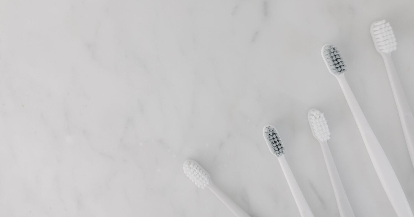 White toothbrushes arranged on a marble surface